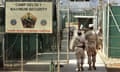 FILE - In this June 27, 2006 file photo, reviewed by a U.S. Department of Defense official, U.S. military guards walk within Camp Delta military-run prison, at the Guantanamo Bay U.S. Naval Base, Cuba. A federal appeals court will reconsider the legality of the only remaining conviction of a Guantanamo Bay detainee who once served as Osama bin Laden's personal assistant. The full U.S. Court of Appeals for the District of Columbia Circuit heard arguments Tuesday after a divided three-judge appeals panel earlier ruled that the conspiracy case against Ali Hamza al-Bahlul is legally flawed because conspiracy is not a war crime.  (AP Photo/Brennan Linsley, File)