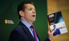 Rhun ap Iorwerth holding up a copy of the manifesto at launch event