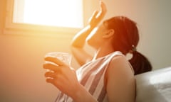 A woman holds a glass of water