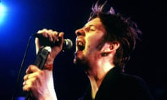 Shane MacGowan singing into a microphone