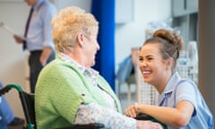 Senior female patient in hospital laughing with nurse on the ward or nursing home.