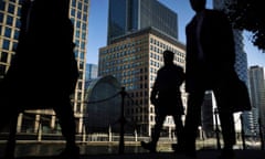 City workers wearing suits walk over London Bridge