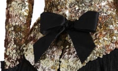 Detail from a cocktail suit from Chanel’s autumn/winter 1991-92 collection, by Karl Lagerfeld – showing a large black bow at the small of the back on a gold sequinned jacket, worn over black skirt
