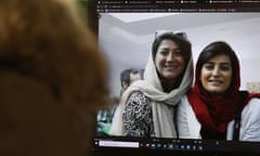 Two young women in headscarves seen on a screen