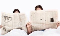 Couple in bed reading newspapers