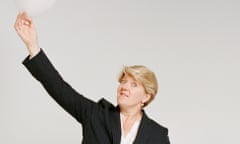 Clare balding wearing a pinstripe suit and white shirt, and holding a white balloon