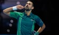 Novak Djokovic puts his finger to his ear and looks to the crowd in Turin