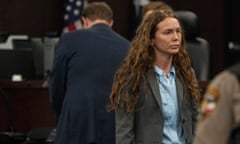 woman with long red hair in a suit in a courtroom