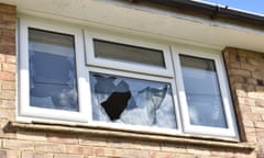 A window frame in a brick wall with smashed panes