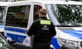 A police officer carries materials gathered during the search of a building in Berlin after a Letzte Generation protest in 2023.