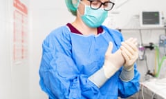 Female doctor putting on protective clothing