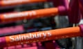 Sainsbury's distinctive orange logo on a line of trolley handles