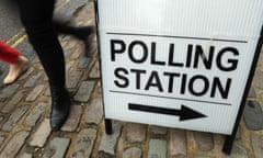 A person walks past a sign for a polling station.