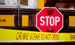 The side of a school bus with cordon tape that reads "CRIME SCENE DO NOT CROSS".