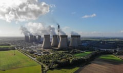 Aerial view of a large power station with several chimneys in a rural landscape