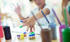 Preschool children fingerpaint in class.