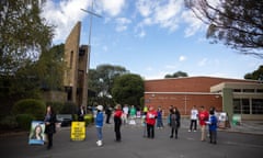 Gladys Liu and the Labor candidate, Carina Garland (in black) wait to greet early Chisholm voters at the Holy Family hall in Mount Waverley.