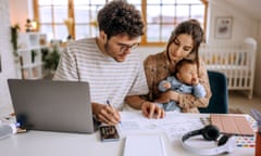 Young family with cute little baby boy going over finances at home