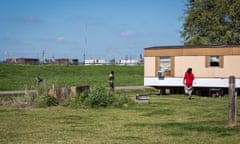 Mobile home in St James Parish with oil tanks in the background. The rise of the oil and petrochemical industry at their doorstep has thrust residents into a financial trap.