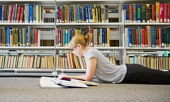 Caucasian woman studying on floor of library