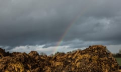 rainbow over field in British countryside against a grey sky<br>M61NFT rainbow over field in British countryside against a grey sky