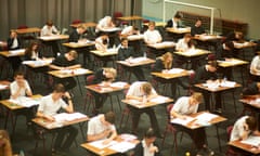 Pupils hunched over question papers in an exam hall.