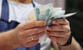 A vendor counts Russian rouble banknotes at a market in St Petersburg, Russia