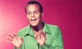 Portrait of Belafonte wearing a green shirt against a red background, circa 1955