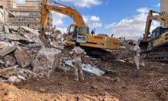 Rescue teams use heavy machinery to dig in the wreckage in Derna