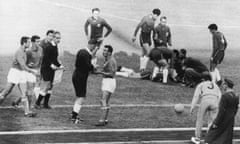 Ken Aston sends off Italy’s Mario David, while an injured Chilean player lies on the ground.