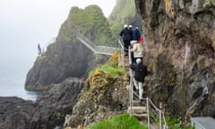 Walkers in hard hats on the Gobbins Cliff Path.