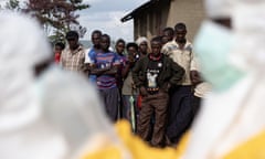 Villagers in Mubende district look on as Red Cross workers don PPE before burying a three-year-old boy who was thought to have Ebola