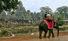Tourists take a guided elephant ride to an ancient temple in Siem Reap, Cambodia.
