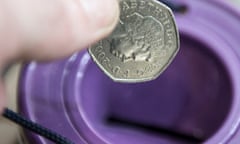 A coin being dropped into a charity collection box