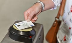 A person using their credit card to pay for a fare at a contactless barrier