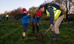 David Elliott, chief executive of Trees for Cities, planting trees with his children Casper and Rafael.