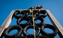 A man climbs over a tire tower