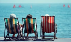 Three older women sitting in deckchairs at the seaside