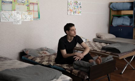 Dmitry Shintsov rests on his bed in a school turned into a refugee shelter 
