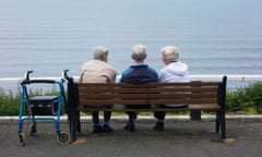 Two elderly men and an elderly woman sitting on bench overloking sea. Saltburn by the Sea, North Yorkshire, England, UK<br>E18H54 Two elderly men and an elderly woman sitting on bench overloking sea. Saltburn by the Sea, North Yorkshire, England, UK