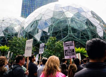 Amazon corporate workers hold picket signs in front of the Amazon Spheres while participating in a walkout to protest.