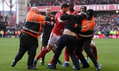 A fan is apprehended on the pitch during Nottingham Forest’s FA Cup win over Leicester.