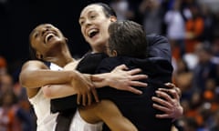 Connecticut’s Morgan Tuck, left rear, Moriah Jefferson, front left, and Breanna Stewart hug Connecticut head coach Geno Auriemma after their perfect season.