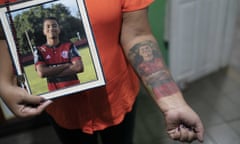 Marilia Barros da Silva shows her tattoo made from the photograph of her son, Arthur Vinicius, who died in a fire at the Flamengo soccer club training complex, in Volta Redonda, Brazil, Thursday, Feb. 6, 2020,  days before the one-year mark since the fire killed 10 academy players and injured three others, all aged between 14 and 16 years-old at the time. (AP Photo/Leo Correa)