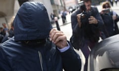 Mazher Mahmood covers his face with his coat as he leaves the Old Bailey