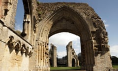 Ruins of Glastonbury Abbey, with one porchway framing two towers in the background