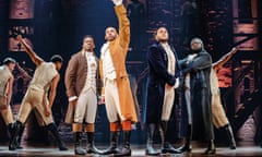 Male cast members of the show Hamilton lined up on stage in costume