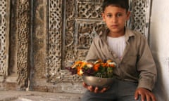 Boy holding a flower offering at the Jibla Mosque, Yemen