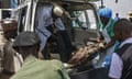 People carry an injured man from the back of a van