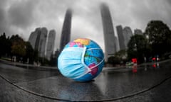 Small world globe on a pavement in China with a face mask